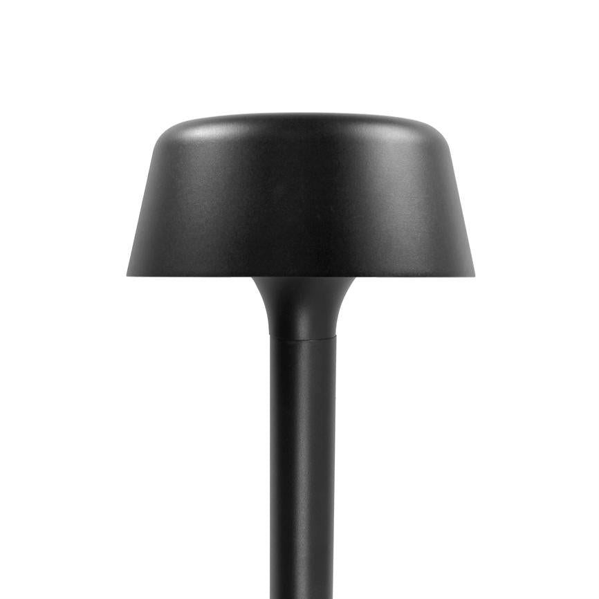 Schwarze Tischleuchte mit rundem, pilzförmigem Schirm, steht aufrecht auf einem schlanken Stab; mattschwarze Oberfläche, minimalistisches Design, platziert vor einem einheitlichen weißen Hintergrund in einem Fotostudio.