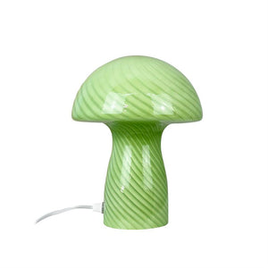 Grüne pilzförmige Lampe mit Spiralstreifen steht auf weißem Hintergrund; glänzende Oberfläche und weißes Netzkabel, das seitlich aus dem Sockel herausgeführt wird.