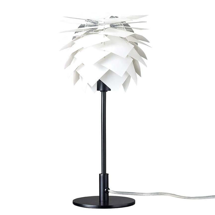 Tischlampe mit weißem „Kegel“-Schirm aus überlappenden Platten, montiert auf schwarzem Metallstab und rundem Sockel; steht auf einem weißen Hintergrund mit einem sichtbaren transparenten Netzkabel.