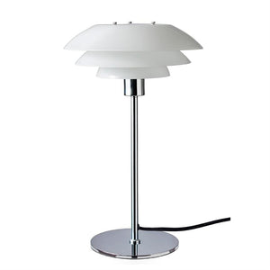 Bordlampe med tre hvide, skålformede skærme på en kromstang og rund kromfod står centralt mod hvid baggrund; sort strømkabel løber ud fra foden.