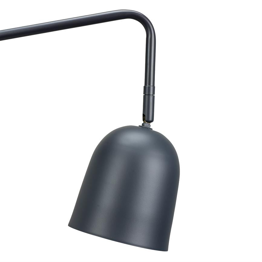An einem gebogenen schwarzen Arm hängt eine dunkelgraue, matte Lampe. Der glockenförmige Bildschirm ist nach unten geneigt vor einem gleichmäßig weißen Hintergrund.