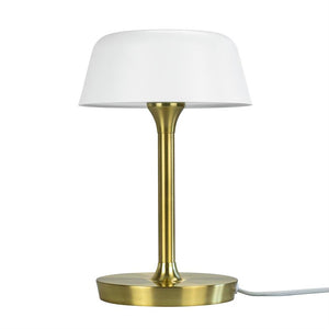 Eine Tischlampe steht mit weißem Schirm auf einem schlanken, gebürsteten Messingstab über einem runden Messingsockel mit sichtbarer weißer Kordel, isoliert vor einem weißen Hintergrund.