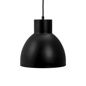 Eine schwarze Metallpendelleuchte hängt an einer dünnen schwarzen Schnur; Seine matte, runde Kuppel schirmt das Licht nach unten vor einem klaren, weißen Hintergrund ab und sorgt so für einen minimalistischen Ausdruck.