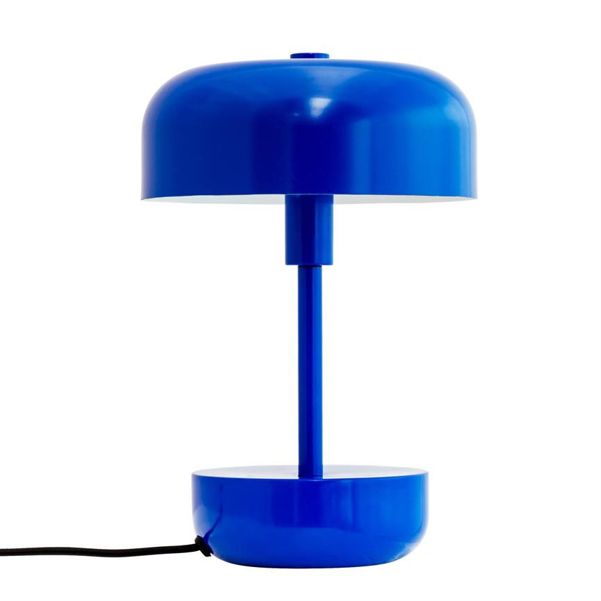 Inmitten eines weißen Hintergrundes steht eine blaue Tischlampe aus Metall mit rundem Schirm und zylindrischem Fuß; Aus dem Sockel der Lampe ragt ein schwarzer Draht heraus.