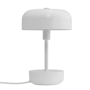Weiße runde Tischlampe steht auf einem schlichten runden Sockel; Eine dünne Säule trägt einen halbkugelförmigen Bildschirm, dargestellt vor einem einheitlichen weißen Hintergrund mit sichtbarer Verkabelung.