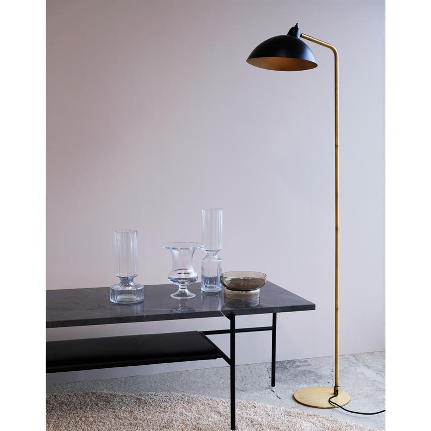 Stehlampe aus Messing steht neben einem niedrigen Marmortisch; Auf dem Tisch stehen drei klare Glasschalen und eine kleine Schüssel, umgeben von einer hellen Wand und einem leichten, weichen Teppich.