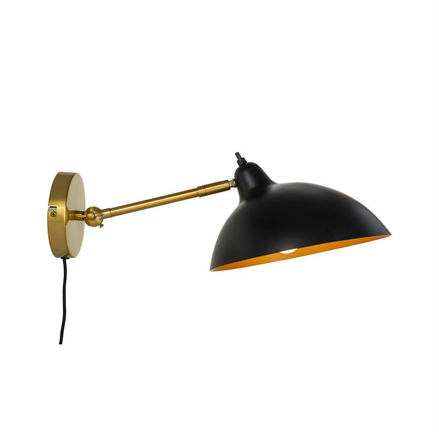 Wandleuchte auf Messinghalterung montiert, verlängerter verstellbarer Arm, schwarzer Schirm mit goldener Innenseite, nach unten gerichtet über einem weißen, minimalistischen Hintergrund.