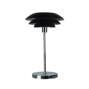 Bordlampe med tre sammenstillede, sorte rundede skærme, monteret på en slank kromstang og rund kromfod; står centralt mod en ensartet hvid baggrund.