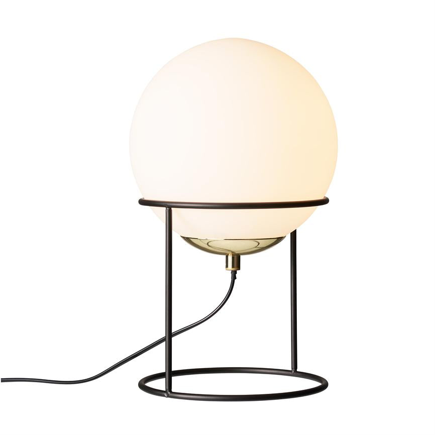 Eine runde, opalweiße Glaskugel leuchtet warm, befestigt in einem schwarzen, offenen Metallständer mit kreisförmigem Sockel; Auf weißem Hintergrund verläuft ein schwarzer Draht von der Unterseite der Lampe nach links.