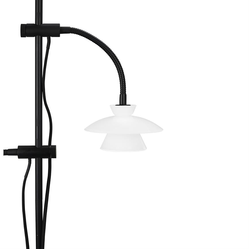 Lampe mit weißem zweiteiligem Schirm hängt an einem schwarzen flexiblen Schlauch, montiert an einer vertikalen schwarzen Stange; Schwarze Drähte verlaufen entlang der Stange nach links auf weißem Hintergrund.