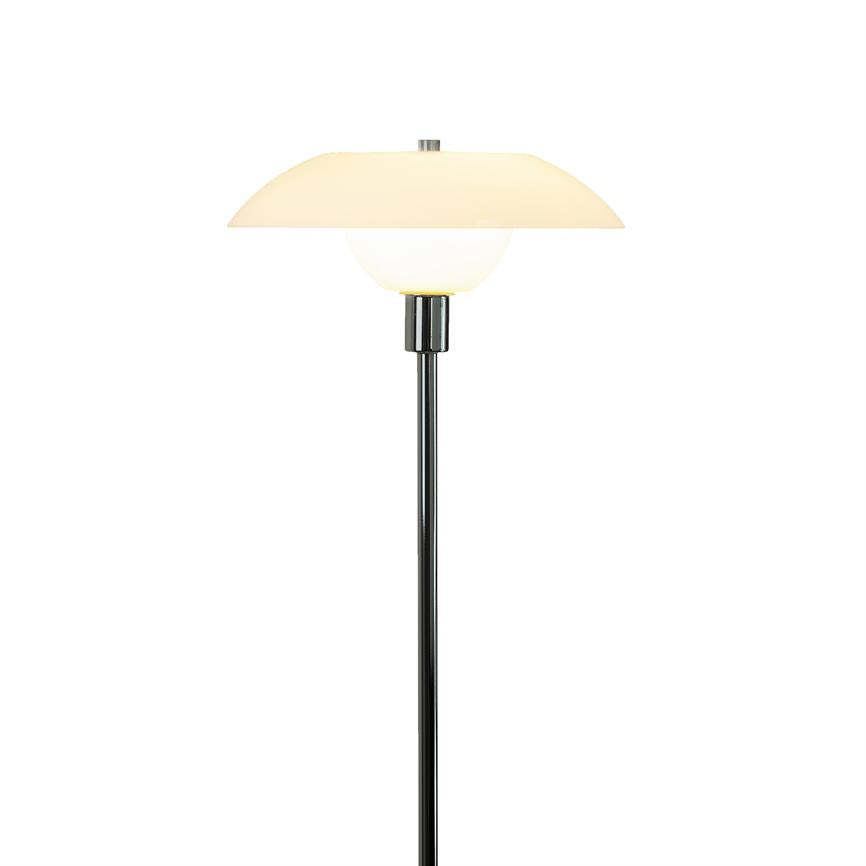 Stehleuchte mit rundem, zweiteiligem Opalglasschirm, spendet sanftes, warmes Licht; steht auf einer schlanken schwarzen Metallstange vor einem schlichten weißen Hintergrund.