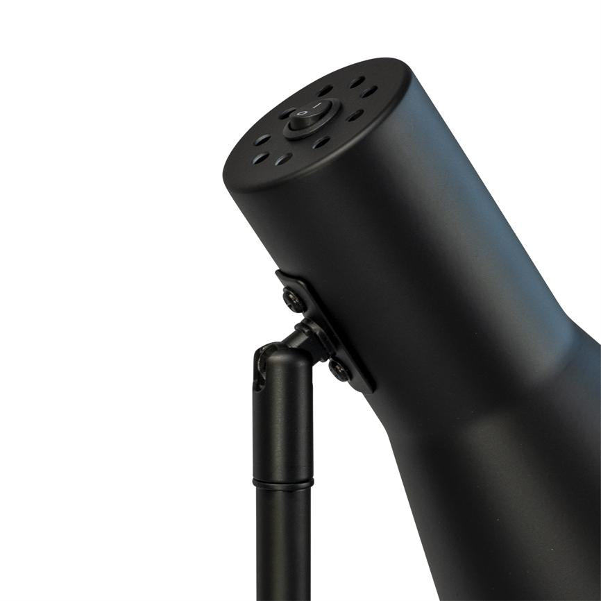 Der Lampenkopf aus schwarzem Metall lässt sich nach vorne neigen und ist über ein verstellbares Scharnier mit einem schlanken Arm verbunden. oben Belüftungslöcher und ein runder Power-Knopf; weißer Hintergrund.