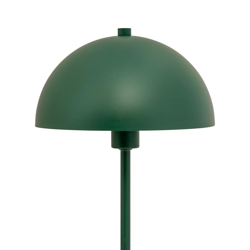 Eine grüne, halbkugelförmige Tischlampe ruht auf einem schlanken Stiel und steht vor einem neutralweißen Studiohintergrund.