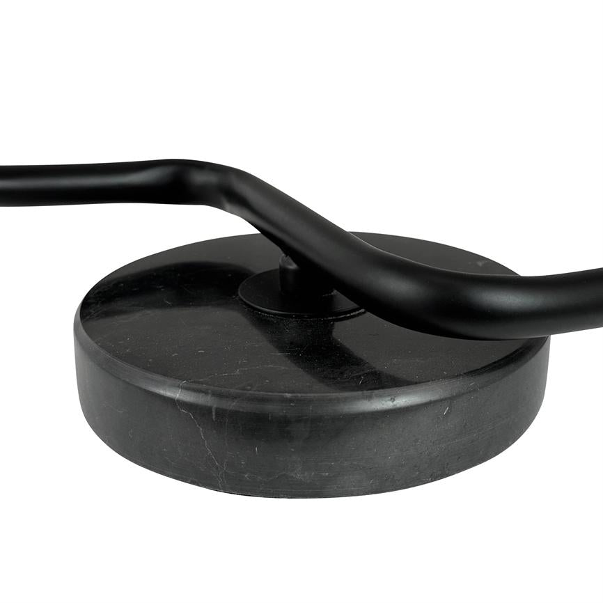 Runder schwarzer Sockel mit oben montiertem gebogenem, mattschwarzem Metallstab; Die Stange biegt sich quer über die Mitte des Sockels und steht vor einem neutralweißen Hintergrund.