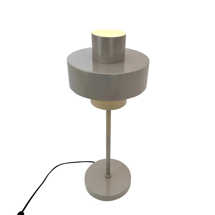Bordlampe står tændt, med to cylindriske skærme (stor midtskærm og mindre top), slank stang på rund base; mat lysgrå metalfinish, sort elledning ligger delvist synlig.