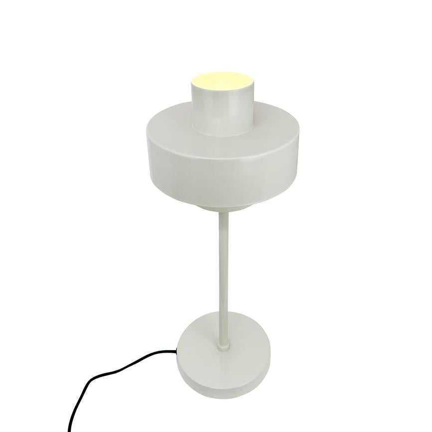 Auf einem schmalen Mast steht eine moderne, weiße Tischleuchte mit rundem Schirm; Die Lampe steht auf einem runden Sockel und ein schwarzes Kabel liegt sichtbar auf einem einheitlichen weißen Hintergrund.
