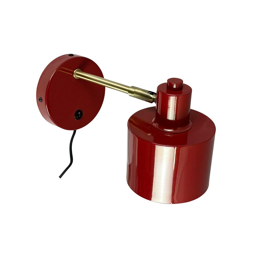 Rote Wandleuchte aus Metall mit zylindrischem Schirm, montiert auf einem verstellbaren Messingarm, runder Wandplatte mit Schalter und sichtbarem schwarzem Kabel, vor einem weißen Hintergrund platziert.