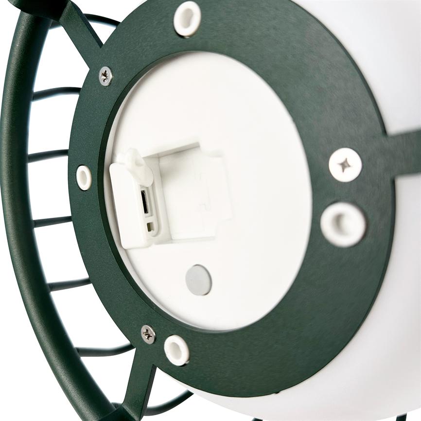 Rund udendørslampe med grøn metalramme, hvis hvide batteridæksel er åbent og afslører en USB-port; nærbillede viser skruer og monteringshuller på hvid baggrund.