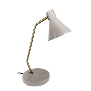 Eine hellgraue Schreibtischlampe richtet ihren konischen Schirm nach unten; Eine gebogene Messingsäule verbindet Bildschirm und runden grauen Sockel auf einem ähnlichen weißen Hintergrund.