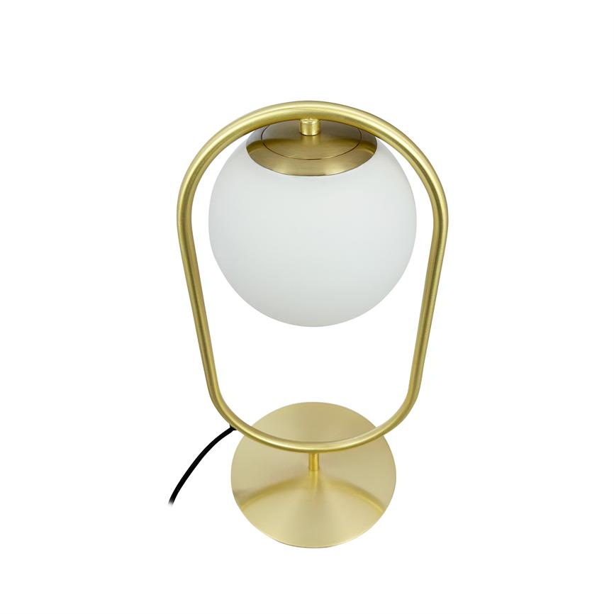 Die Tischleuchte trägt eine weiße Milchglaskugel, die zentral in einem ovalen Messingrahmen hängt; Die Lampe steht auf einem runden Messingsockel mit sichtbarem schwarzem Kabel vor einem neutralweißen Hintergrund.