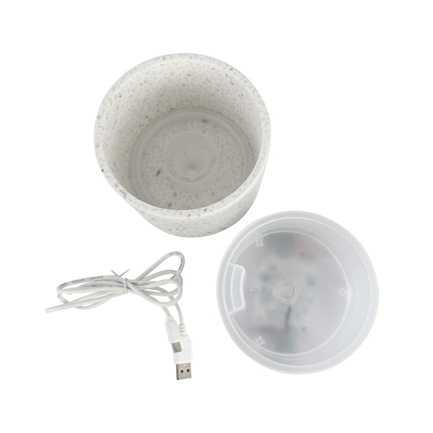 Weißer, bunter zylindrischer Behälter; es ist in drei Teile geteilt mit einem transparenten Kunststoffdeckel und einem aufgerollten USB-Kabel; Die Teile liegen auf einem weißen Hintergrund.