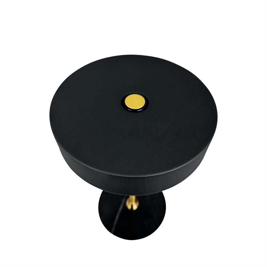 Schwarze, runde Tischleuchte mit gelbem Druckknopf in der Mitte; Es steht auf einem weißen Hintergrund, von oben gesehen, wobei die obere Scheibe und ein Teil des Ständers sichtbar sind.