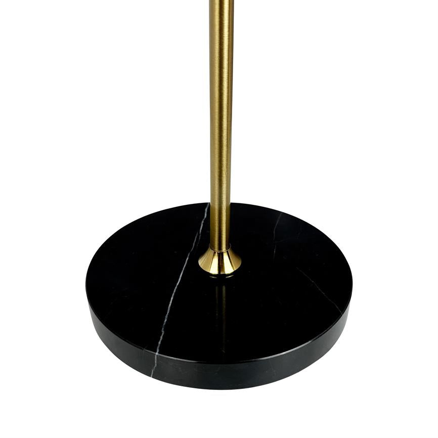 Ein runder, schwarzer Marmorsockel trägt einen schlanken, vertikalen, goldfarbenen Metallstab; Der Marmor hat dünne weiße Adern und steht vor einem reinweißen Hintergrund.