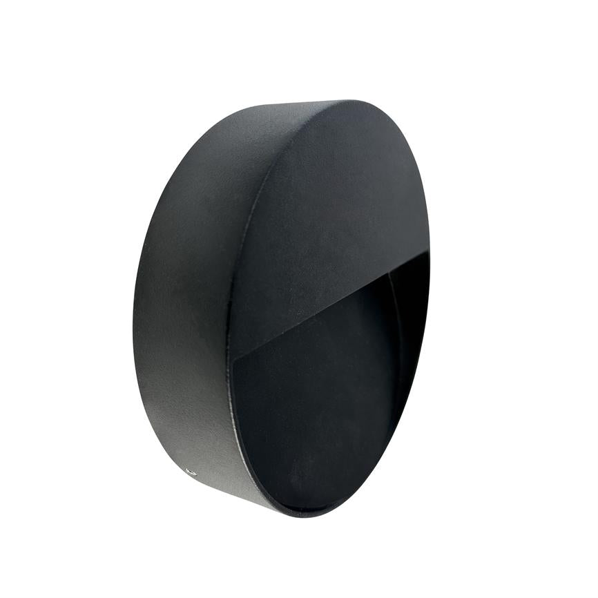 Sort rund væglampe med diagonal afskærmning, der skjuler lyskilden; halvkugleformet hus monteret mod hvid baggrund, mat sort metalfinish.