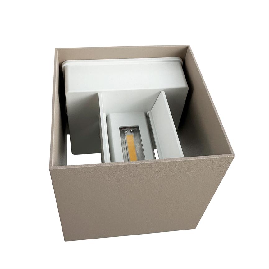 Kvadratisk væglampe med synligt LED-modul; den afslører indvendig reflektor og køleprofil uden at være tændt; beige metalkasse præsenteret mod hvid baggrund.