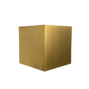 Goldwürfel steht mittig auf weißem Hintergrund; Zwei Gesichter und eine Ecke sind sichtbar, mit sanften Lichtreflexionen auf der matten, goldenen Oberfläche.