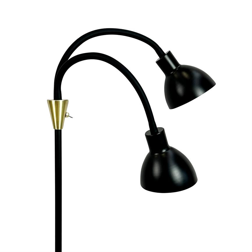 Gulvlampe med to bøjede, fleksible arme; hver afsluttet af en sort, skålformet skærm rettet nedad. Sort metalstang med guldfarvet konisk kobling, vist på hvid baggrund.