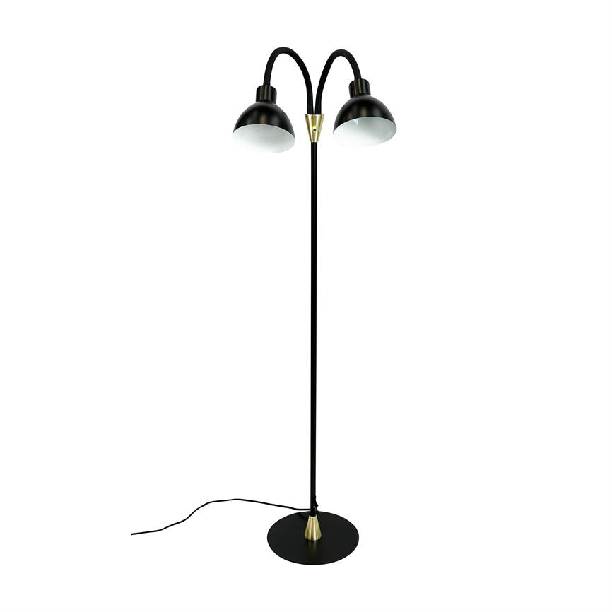 En sort gulvlampe med to buede skærme; armene bøjer udad og peger let nedad; står på rund sort fod med messingdetaljer og synlig sort ledning mod hvid baggrund.