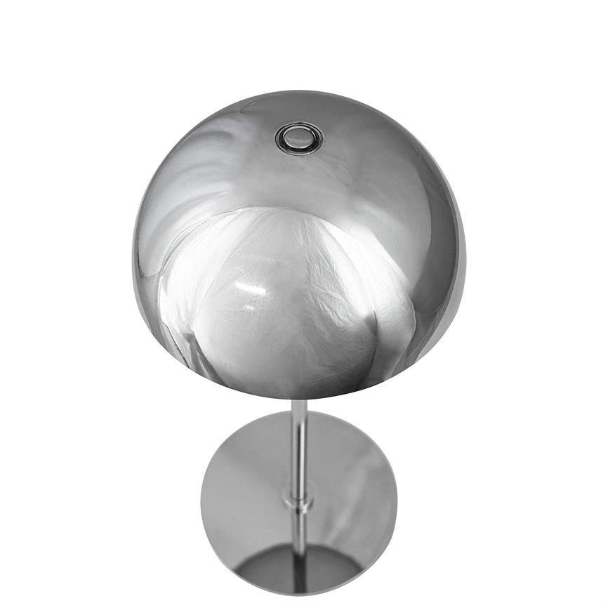 Tischleuchte aus Chrom mit runder Kuppel, steht auf schlankem Pfosten; Die Kuppel reflektiert weiße Materie und Licht vor einem neutralweißen Hintergrund.