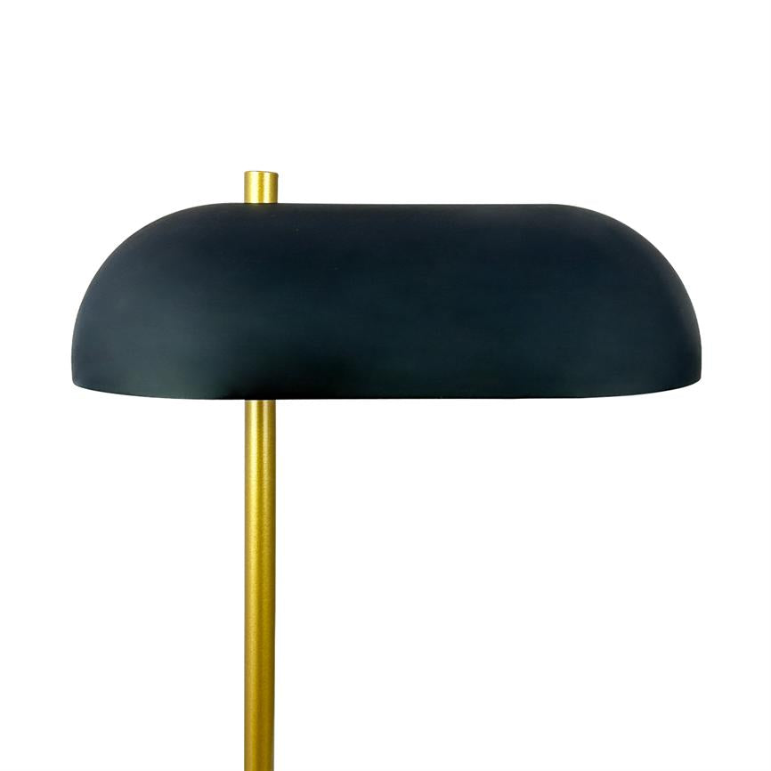 Lampe med sort, halvkugleformet skærm hviler på en slank guldfarvet stang i et lyst, minimalistisk miljø med ensartet hvid baggrund.