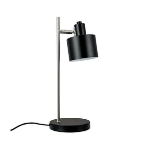 Schreibtischlampe mit schwarzem zylindrischem Schirm, neigbarem Kopf, montiert auf einem schlanken silbernen Stab und rundem schwarzem Sockel; Schwarzer Draht liegt seitlich auf weißem Hintergrund.