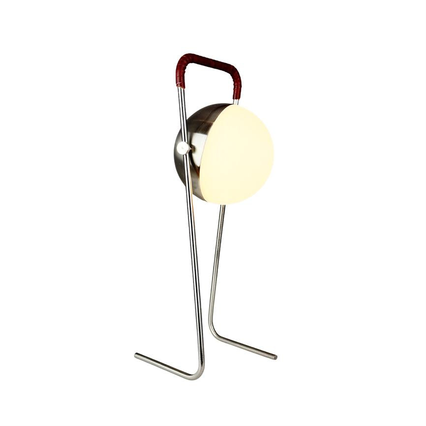 Standerlampe udsender blødt, varmt lys fra en rund, hvid skærm; den står på et slankt kromstativ med to ben og et rødt læderindbundet håndtag, fotograferet mod hvid baggrund.