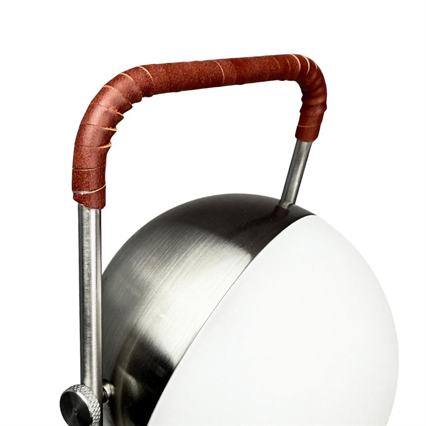 Lampe med rund, børstet stålskærm og hvid front, hvis buede metalhåndtag er viklet ind i brunt læder, placeret mod en hvid studiebaggrund.