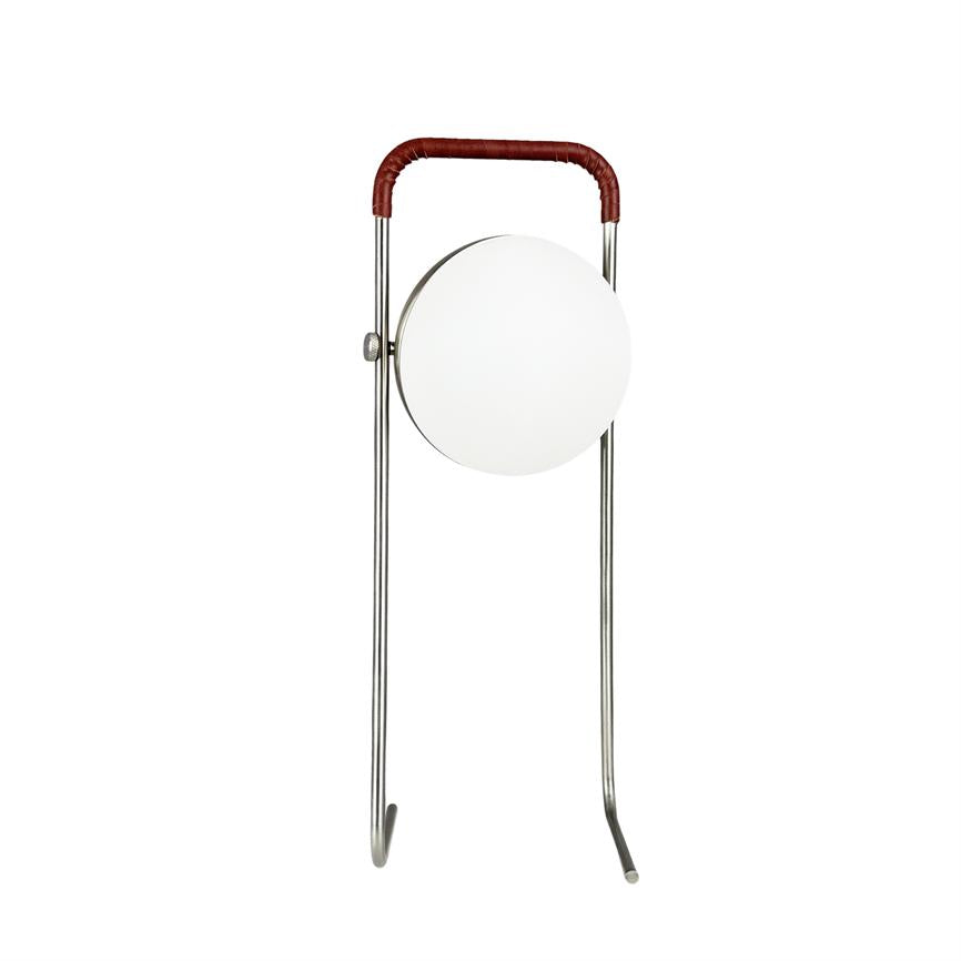 Stående lampe med to tynde, forkromede ben og et brunt håndtag, som holder en rund, hvid opal skærm hængende midt mellem benene på hvid baggrund.